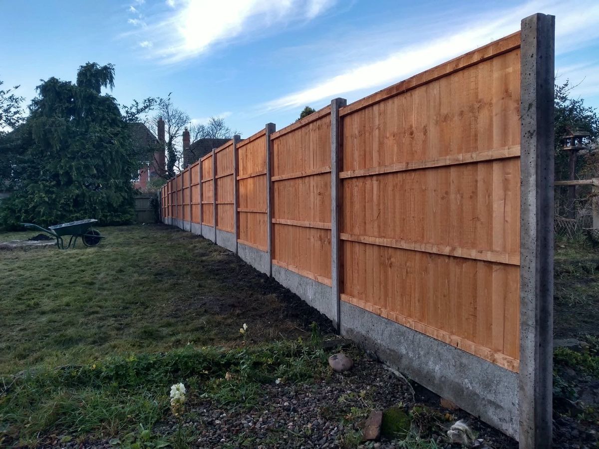 Newly installed close-board timber fence with concrete posts and gravel boards