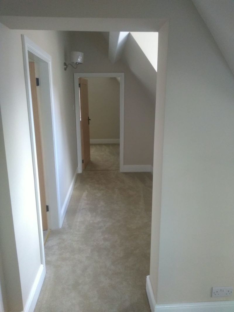Finished landing with freshly painted walls, white doors and new carpet
