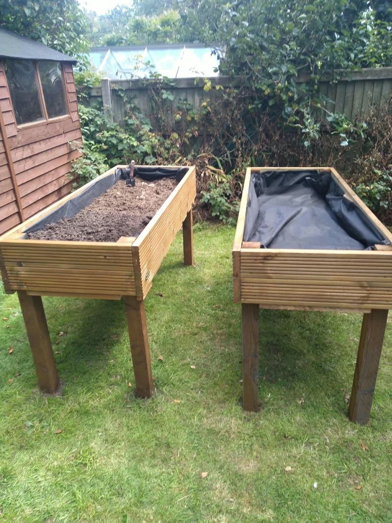 Two raised timber planters on legs, built for a garden