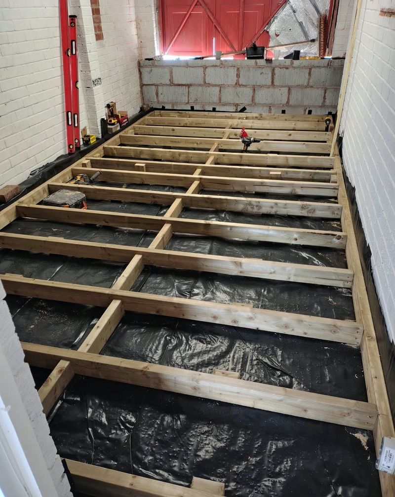 New timber floor joists laid in a grid over a damp-proof membrane